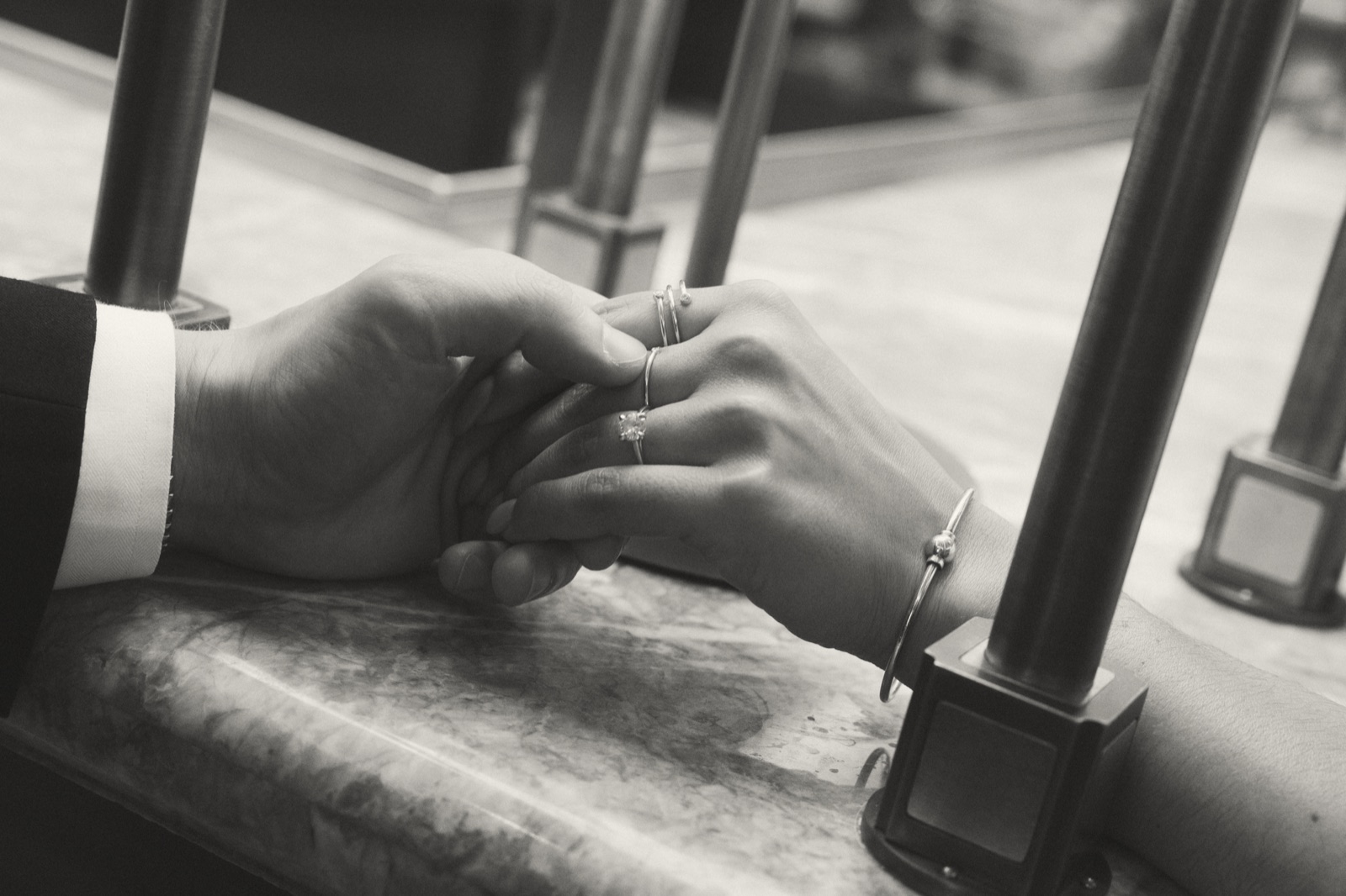 A black and white close-up of Mark and Vivian holding hands